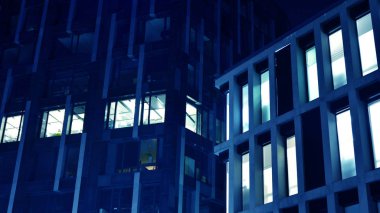 Gece mimarisi - cam cepheli bina. İş bölgesinde modern bir bina. Ekonomi kavramı, finans. Dışarıdaki ticari ofis binasının fotoğrafı. Ofis binasının soyut görüntüsü