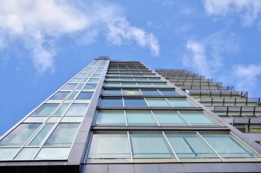 Çelik ve cam mavi gökyüzü ile modern ofis binası duvar yapılmış