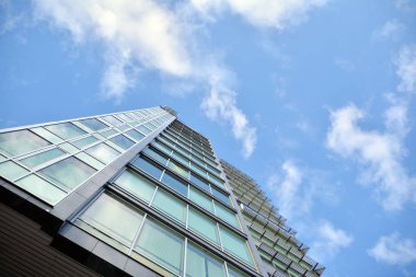 Çelik ve cam mavi gökyüzü ile modern ofis binası duvar yapılmış