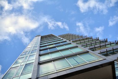 Çelik ve cam mavi gökyüzü ile modern ofis binası duvar yapılmış