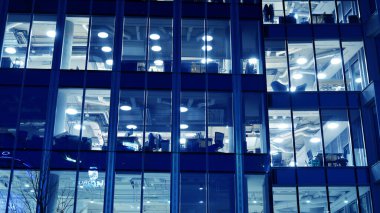 Gece mimarisi - cam cepheli bina. Gece ışıklarının mavi rengi. İş bölgesinde modern bir bina. Ekonomi kavramı, mali. 