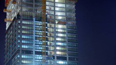 Ofis binalarının pencereleri gece aydınlandı. Şehir merkezinde yansıması olan cam mimari cephe tasarımı ile ışıklandırma.