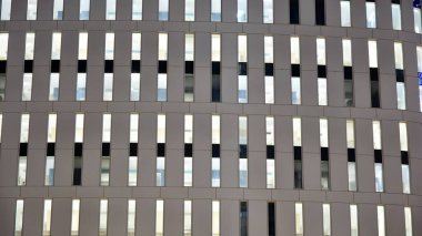 Ofis binalarının pencereleri gece aydınlandı. Şehir merkezinde yansıması olan cam mimari cephe tasarımı ile ışıklandırma.