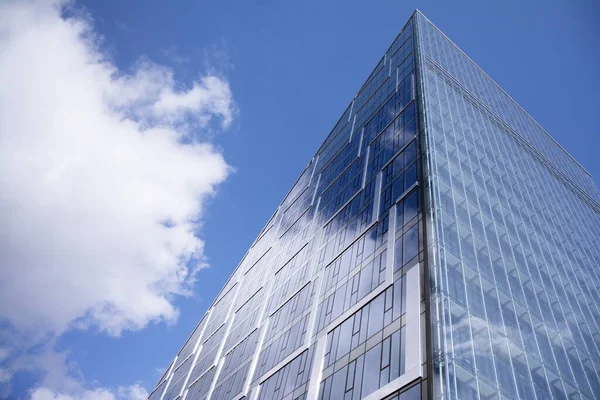 ガラスと鋼で作られた近代的なカーテンウォール 近代的なオフィスビルの窓に映る青空と雲 — ストック写真