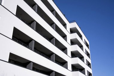 Mavi gökyüzü olan güneşli bir günde modern apartman binaları. Modern bir apartmanın cephesi