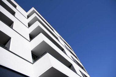 Mavi gökyüzü olan güneşli bir günde modern apartman binaları. Modern bir apartmanın cephesi