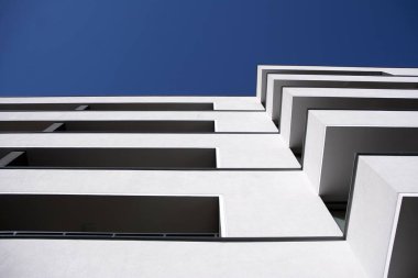 Mavi gökyüzü olan güneşli bir günde modern apartman binaları. Modern bir apartmanın cephesi