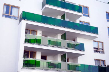 Mavi gökyüzü olan güneşli bir günde modern apartman binaları. Modern bir apartmanın cephesi