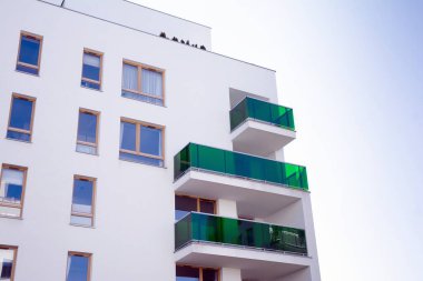 Mavi gökyüzü olan güneşli bir günde modern apartman binaları. Modern bir apartmanın cephesi