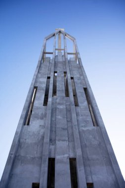 Mavi gökyüzünün altındaki modern kilisenin çan kulesinde çapraz. 