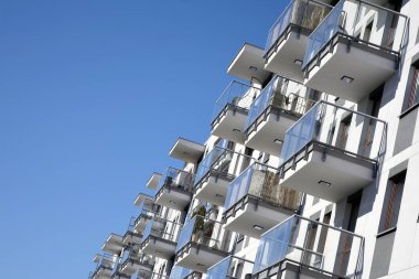 Mavi gökyüzü olan güneşli bir günde modern apartman binaları. Modern bir apartmanın cephesi