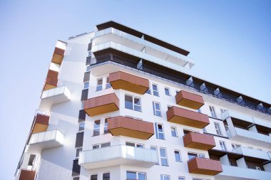 Mavi gökyüzü olan güneşli bir günde modern apartman binaları. Modern bir apartmanın cephesi