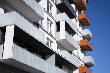 Mavi gökyüzü olan güneşli bir günde modern apartman binaları. Modern bir apartmanın cephesi
