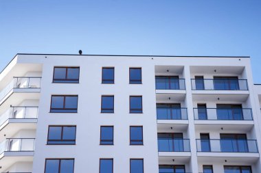 Mavi gökyüzü olan güneşli bir günde modern apartman binaları. Modern bir apartmanın cephesi