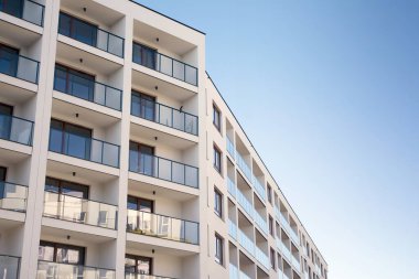 Mavi gökyüzü olan güneşli bir günde modern apartman binaları. Modern bir apartmanın cephesi