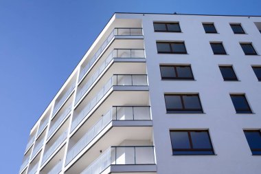 Mavi gökyüzü olan güneşli bir günde modern apartman binaları. Modern bir apartmanın cephesi