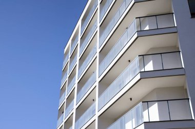 Mavi gökyüzü olan güneşli bir günde modern apartman binaları. Modern bir apartmanın cephesi