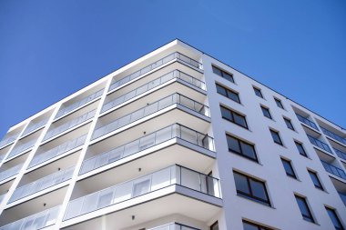 Mavi gökyüzü olan güneşli bir günde modern apartman binaları. Modern bir apartmanın cephesi
