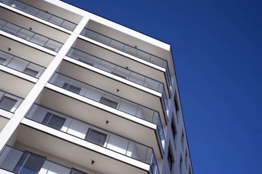 Mavi gökyüzü olan güneşli bir günde modern apartman binaları. Modern bir apartmanın cephesi
