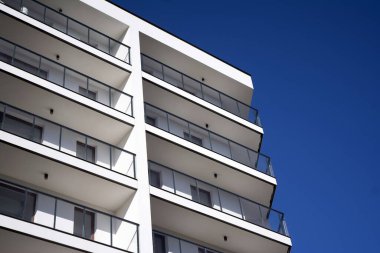 Mavi gökyüzü olan güneşli bir günde modern apartman binaları. Modern bir apartmanın cephesi