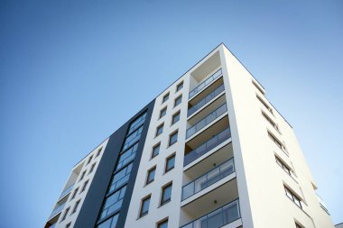 Mavi gökyüzü olan güneşli bir günde modern apartman binaları. Modern bir apartmanın cephesi