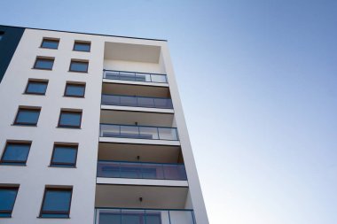 Mavi gökyüzü olan güneşli bir günde modern apartman binaları. Modern bir apartmanın cephesi