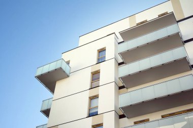 Mavi gökyüzü olan güneşli bir günde modern apartman binaları. Modern bir apartmanın cephesi