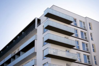Mavi gökyüzü olan güneşli bir günde modern apartman binaları. Modern bir apartmanın cephesi