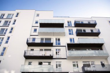 Mavi gökyüzü olan güneşli bir günde modern apartman binaları. Modern bir apartmanın cephesi