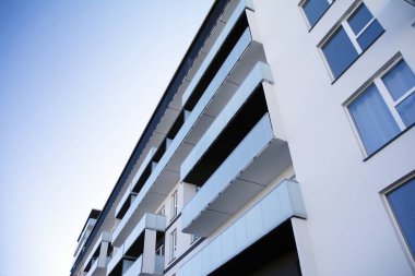 Mavi gökyüzü olan güneşli bir günde modern apartman binaları. Modern bir apartmanın cephesi