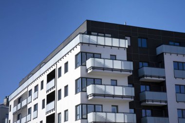 Mavi gökyüzü olan güneşli bir günde modern apartman binaları. Modern bir apartmanın cephesi