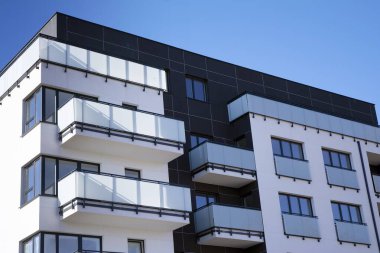Mavi gökyüzü olan güneşli bir günde modern apartman binaları. Modern bir apartmanın cephesi