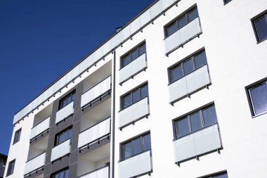 Mavi gökyüzü olan güneşli bir günde modern apartman binaları. Modern bir apartmanın cephesi