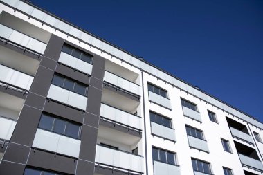 Mavi gökyüzü olan güneşli bir günde modern apartman binaları. Modern bir apartmanın cephesi