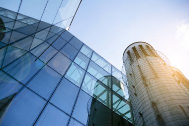 Açık güneşli bir günde mavi gökyüzünde güneş ışınlarıyla cam cepheler inşa eden ofis. Güneş ışığına sahip bir gökdelenin soyut görüntüsü