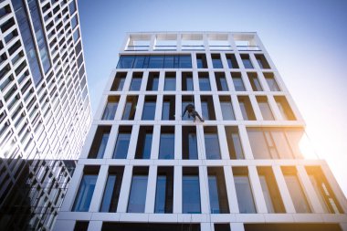 Gün doğumu, yansıma ve perspektifli ofis binası manzarası. İş için parlak bir bakış açısı. Güneşli gökyüzü olan modern ofis bloğu.