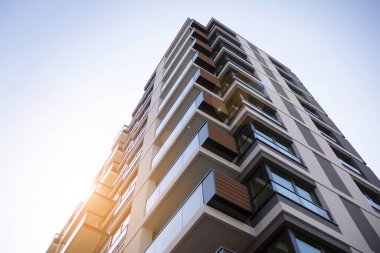 Apartman, ev ve dış görünüş mimarisi ve açık hava tesisleri. Arka planda mavi gökyüzü. Güneş ışığı