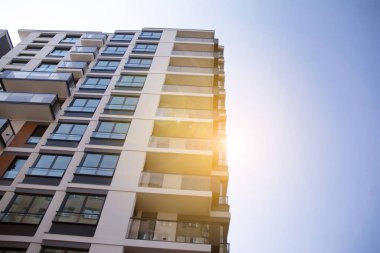 Apartman, ev ve dış görünüş mimarisi ve açık hava tesisleri. Arka planda mavi gökyüzü. Güneş ışığı