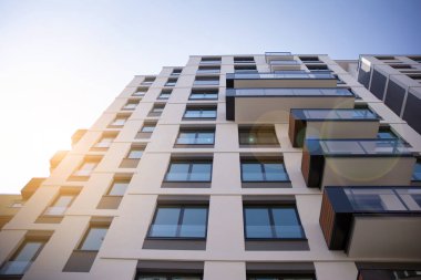 Apartman, ev ve dış görünüş mimarisi ve açık hava tesisleri. Arka planda mavi gökyüzü. Güneş ışığı