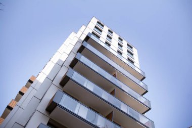 Şehir mimarisinde cam cepheli balkonları olan çok katlı güzel bir ev, satılık lüks emlak daireleri..