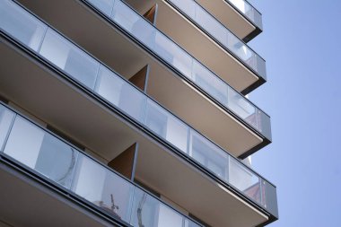 Şehir mimarisinde cam cepheli balkonları olan çok katlı güzel bir ev, satılık lüks emlak daireleri..