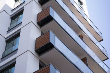 Şehir mimarisinde cam cepheli balkonları olan çok katlı güzel bir ev, satılık lüks emlak daireleri..