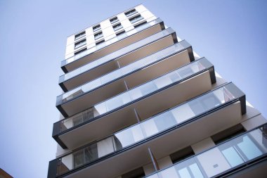 Şehir mimarisinde cam cepheli balkonları olan çok katlı güzel bir ev, satılık lüks emlak daireleri..