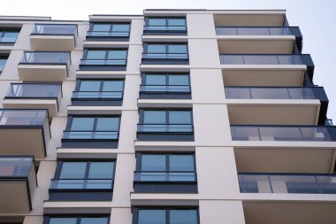 Şehir mimarisinde cam cepheli balkonları olan çok katlı güzel bir ev, satılık lüks emlak daireleri..