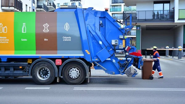 Varşova, Polonya. 10 Nisan 2020. Kamu hizmetleri işçisi çöp tenekelerinden çöp topluyor.. 