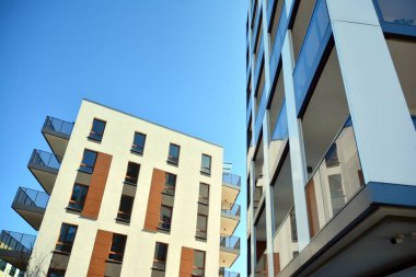 Mavi gökyüzü olan güneşli bir günde modern ve yeni bir apartman. Gündüz gözüyle çağdaş yerleşim yerinin dış tarafında..