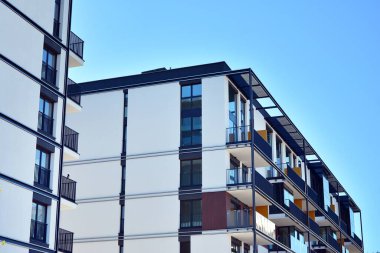 Mavi gökyüzü olan güneşli bir günde modern ve yeni bir apartman. Gündüz gözüyle çağdaş yerleşim yerinin dış tarafında..