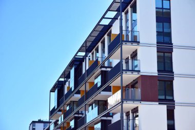 Mavi gökyüzü olan güneşli bir günde modern ve yeni bir apartman. Gündüz gözüyle çağdaş yerleşim yerinin dış tarafında..