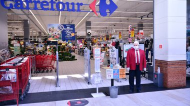 Varşova, Polonya. 16 Nisan 2020. Marketin içinde Carrefour. Müşteriler ve mağaza personeli koruyucu maskeler takıyor. Koronavirüsü durdurun..