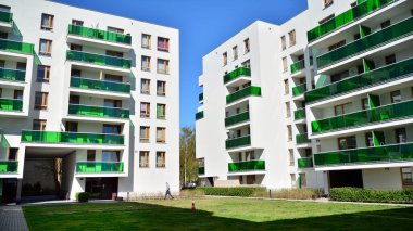 Varşova, Polonya. 17 Nisan 2020. Güneşli bir günde, Bielany bölgesindeki modern apartmanda mavi gökyüzü. Modern bir apartman cephesi.